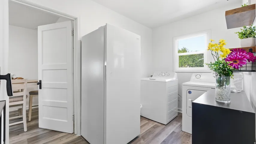 Bright utility area featuring wood-finish flooring, white walls, and a window