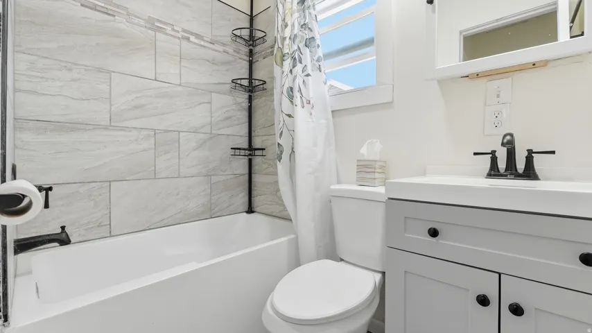 White vanity with black hardware, white countertop, and black faucet