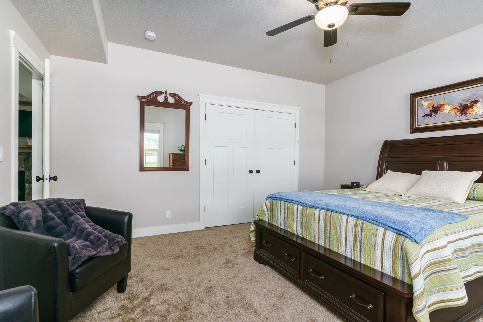Carpeted flooring, white trim, paneled closet doors, and a ceiling fan with integrated lighting
