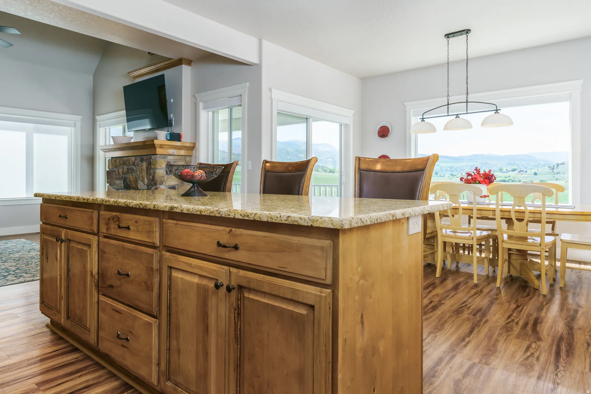Kitchen island with stone-look countertop, wood-finish flooring, and built-in cabinetry