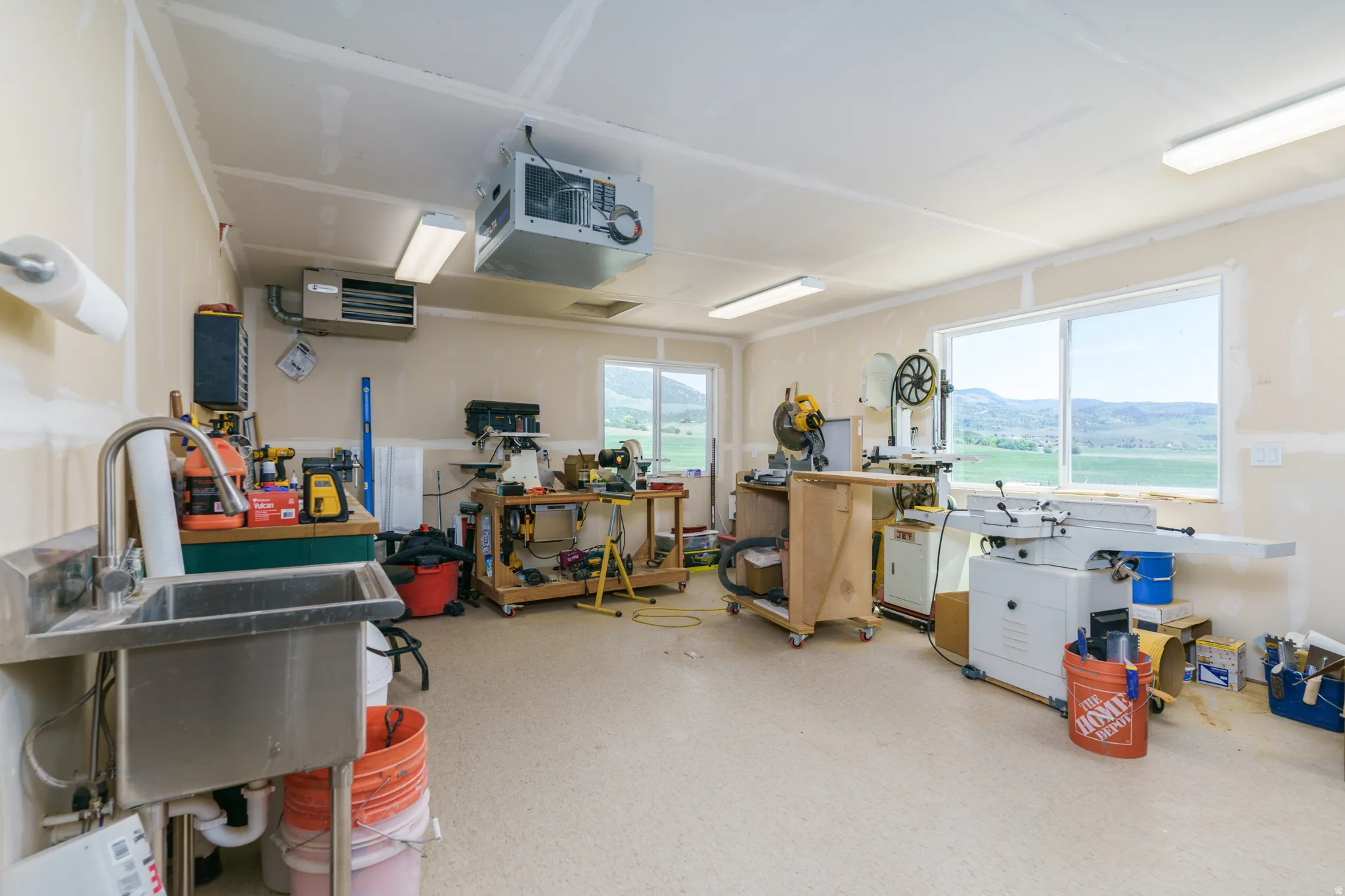 Utility room featuring an industrial sink, multiple windows, and suspended ceiling-mounted fixtures