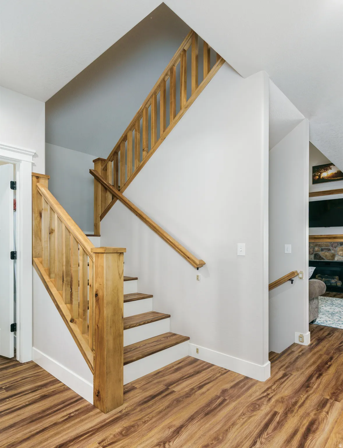 Staircase with wood-finish treads and risers, complemented by natural wood handrails and balusters
