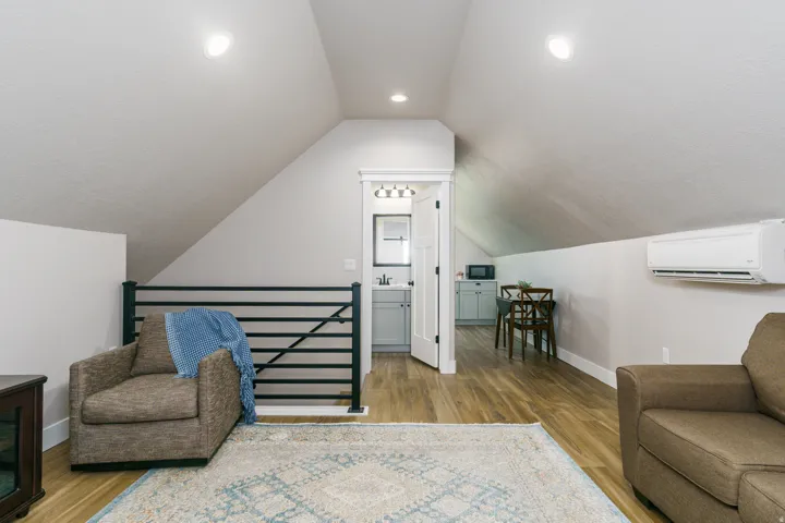 Sloped ceilings, wood-finish flooring, recessed lighting, and a built-in mini-split system