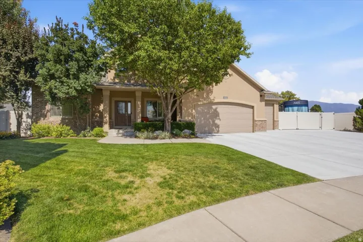 Stucco exterior with stone accents, covered entry, and an attached two-car garage