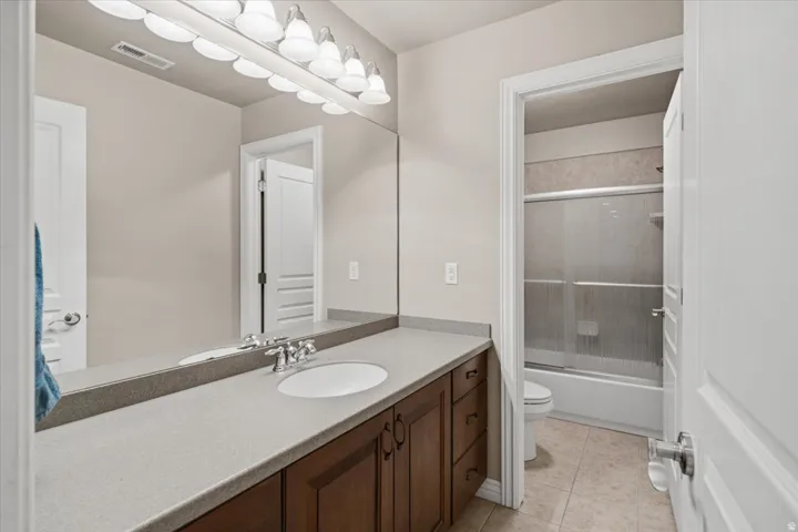 Integrated vanity with dual sinks, wood-finish cabinetry, and a light-toned countertop