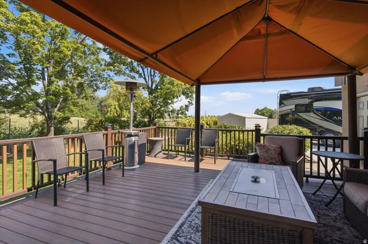 Expansive outdoor deck featuring composite decking, wood railings, and a large canopy