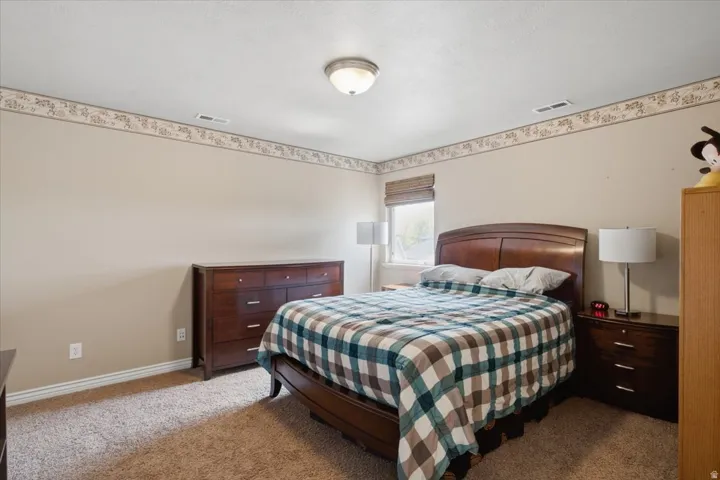 Wall-to-wall carpeting, window with blinds, and a ceiling-mounted light fixture