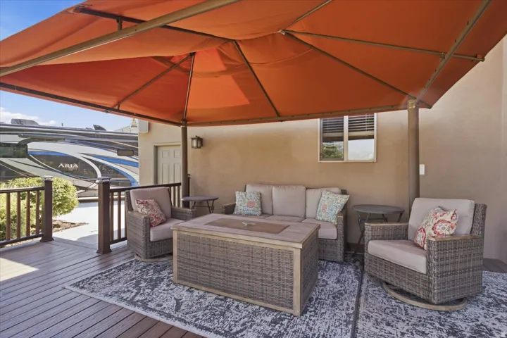 Deck with an orange canopy, dark wood-finish railing, and an exterior wall sconce