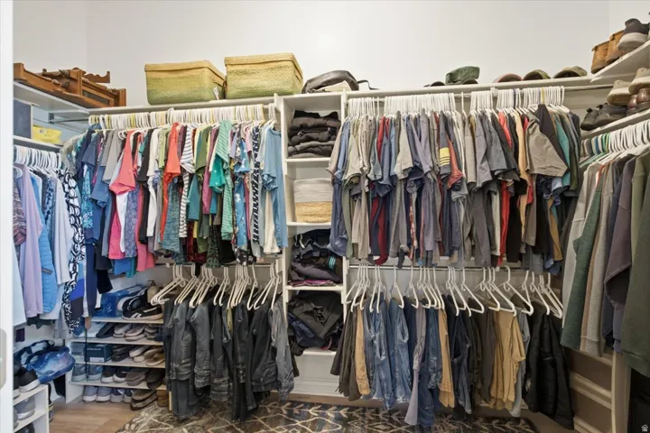 Built-in closet system featuring multiple hanging rods, dedicated shelving, and shoe storage