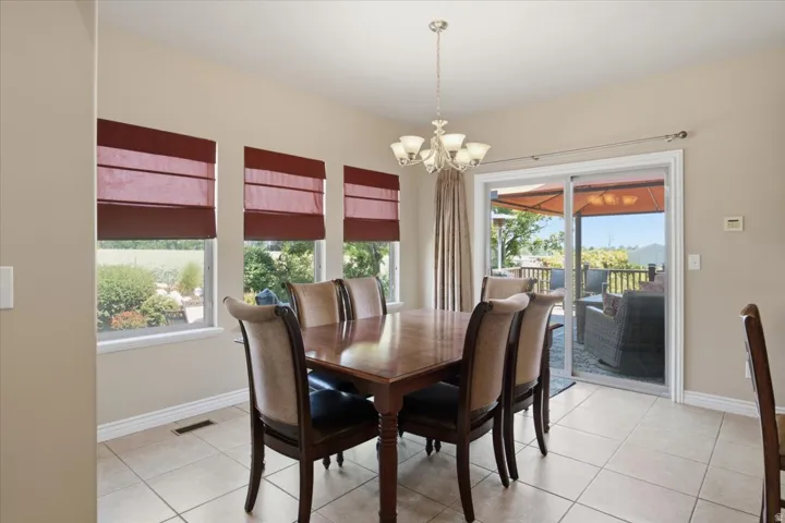 Recessed lighting, chandelier, multiple windows, sliding glass door, and tiled flooring