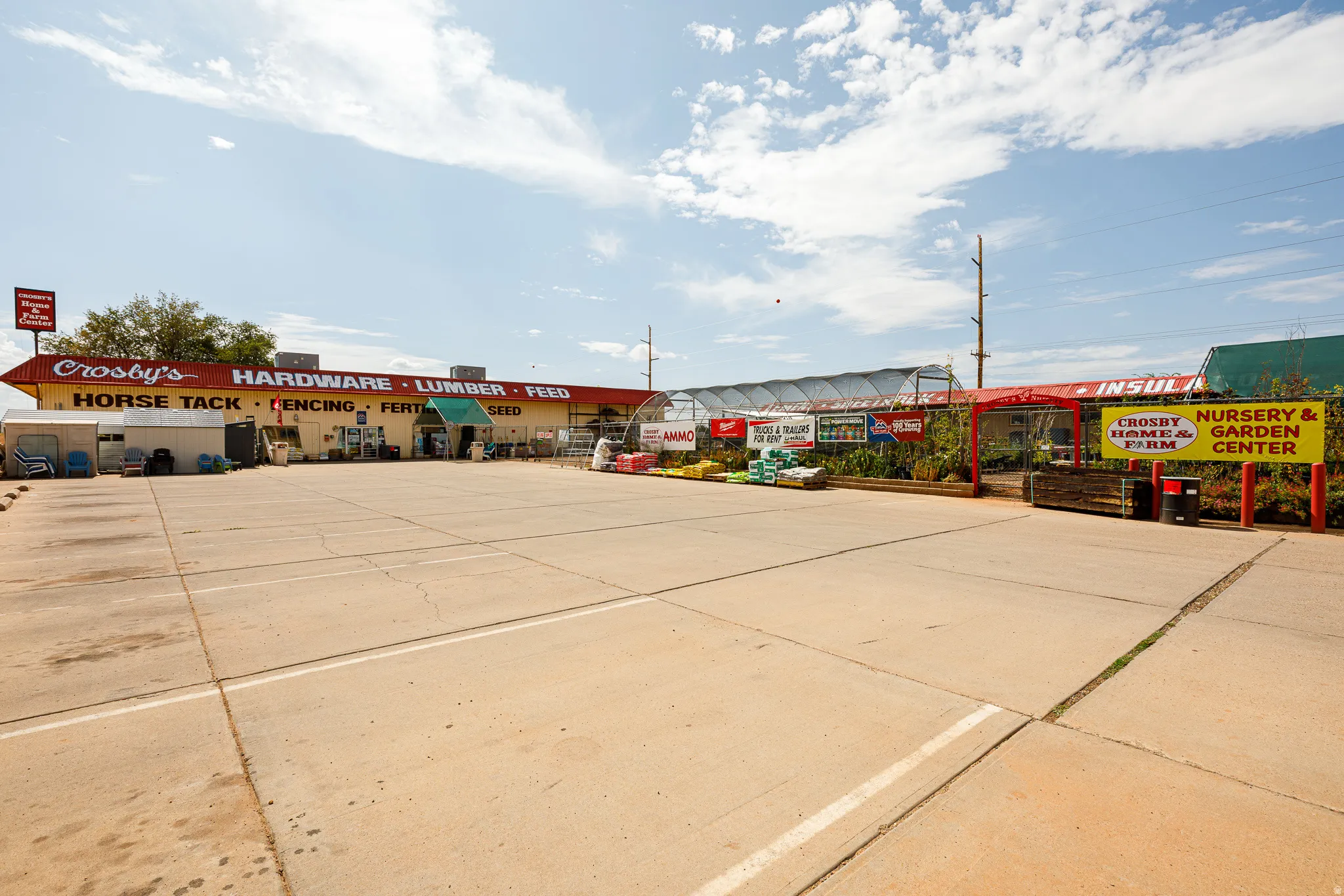 Expansive concrete parking lot, multiple commercial buildings, and a large nursery and garden center