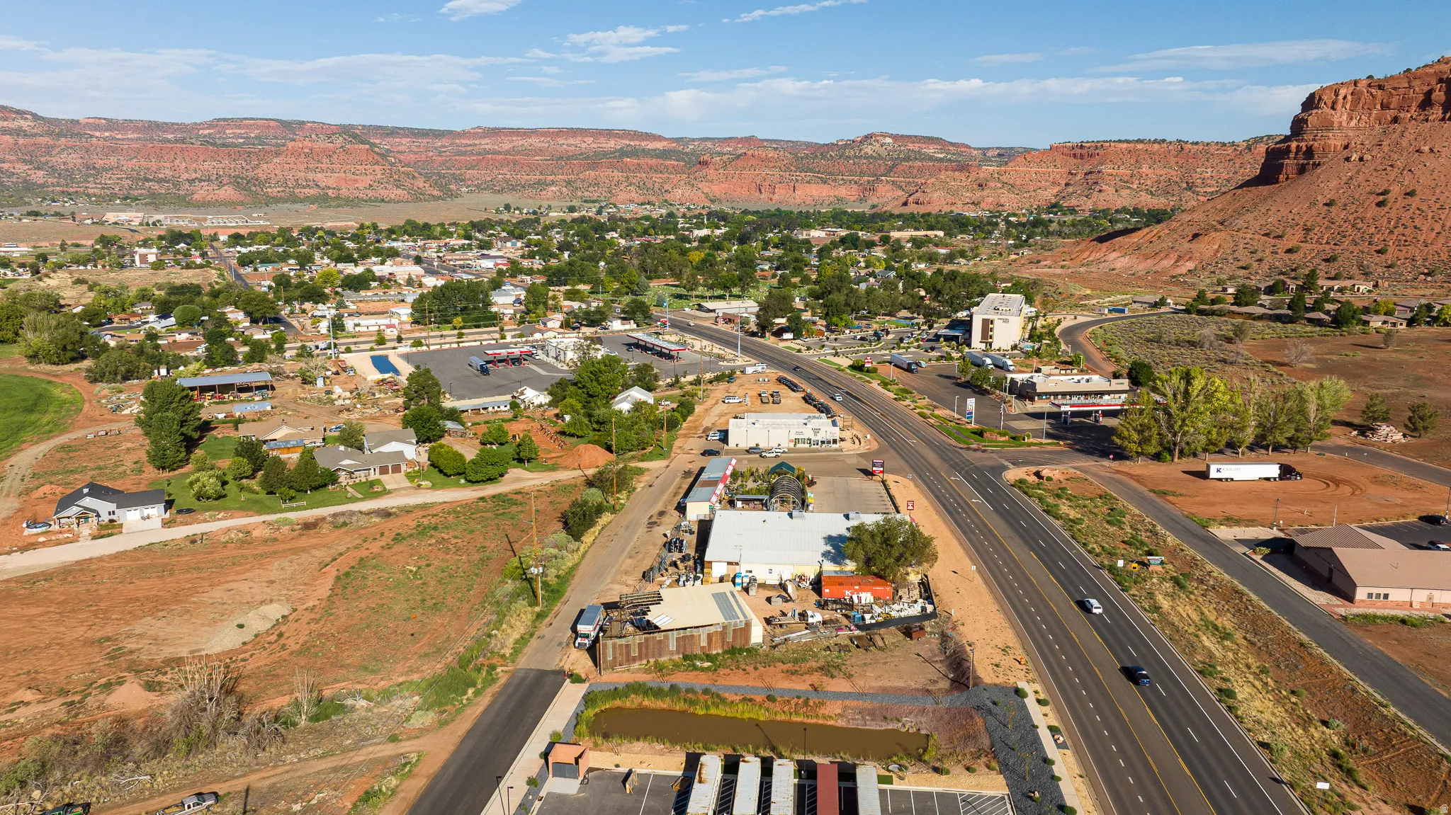 Aerial view showcasing a commercial property with modern structures, paved parking areas, and landscaped grounds
