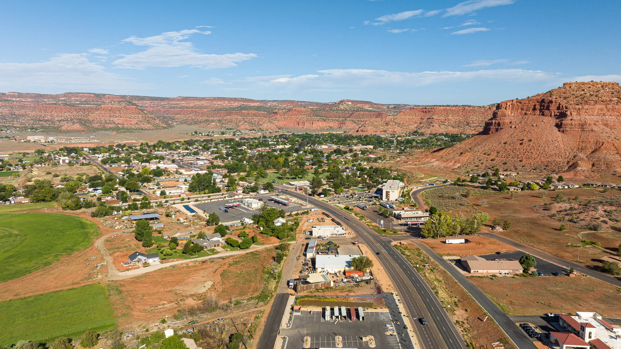 Expansive aerial view showcasing a developed area with extensive roadways, commercial structures, and residential buildings