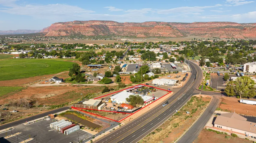 Commercial property featuring a multi-lane highway frontage, multiple buildings, and an expansive paved parking area