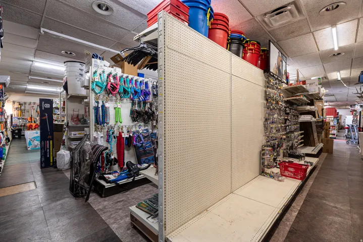 Commercial retail space with pegboard wall displays, recessed ceiling lighting, and overhead fluorescent lighting