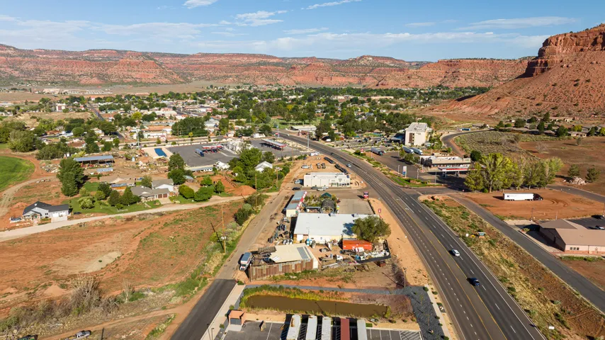Aerial view showcasing a commercial property with modern structures, paved parking areas, and landscaped grounds