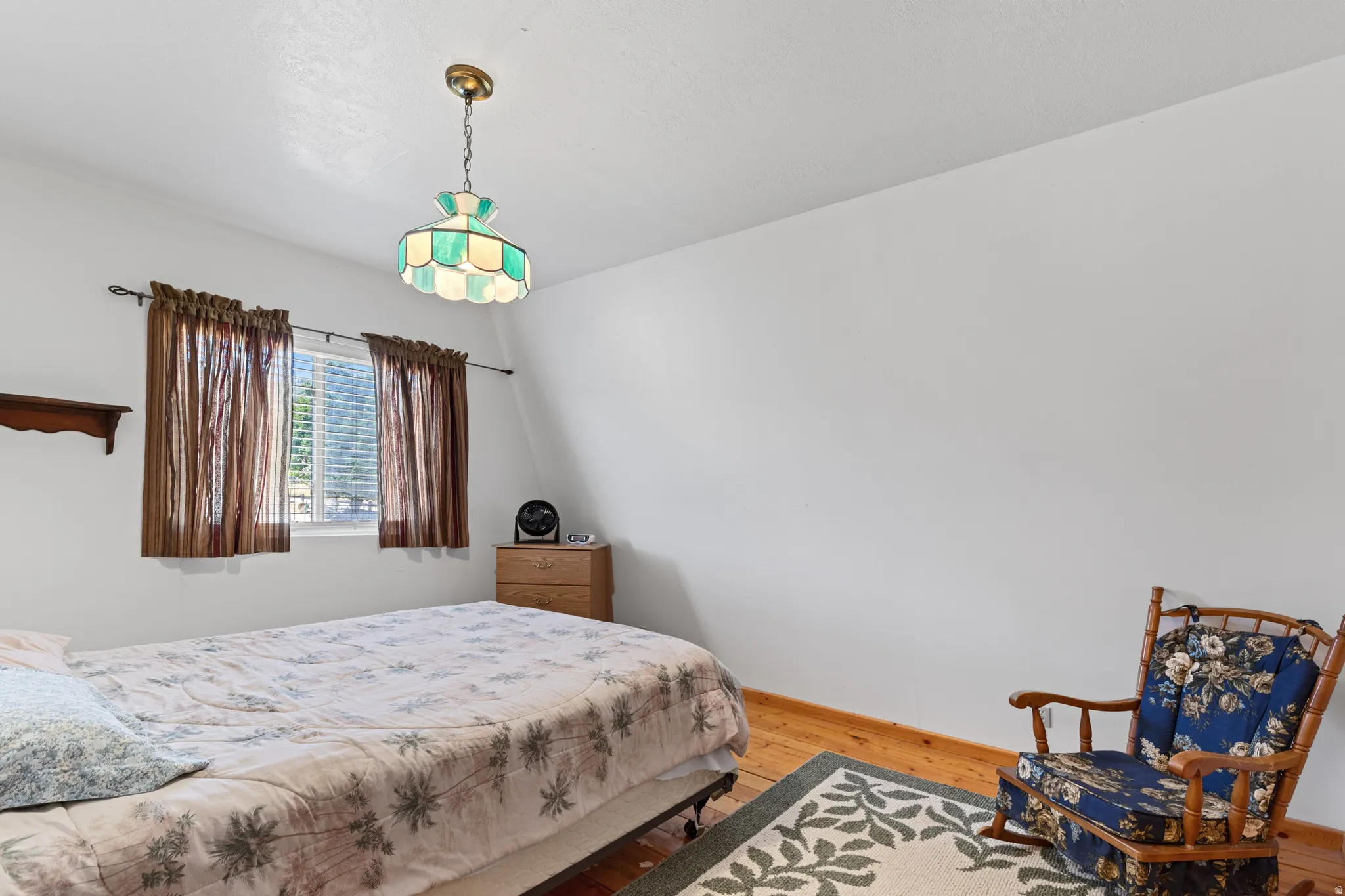 Wood-finish flooring, single window with blinds, recessed ceiling light fixture, and white wall finishes