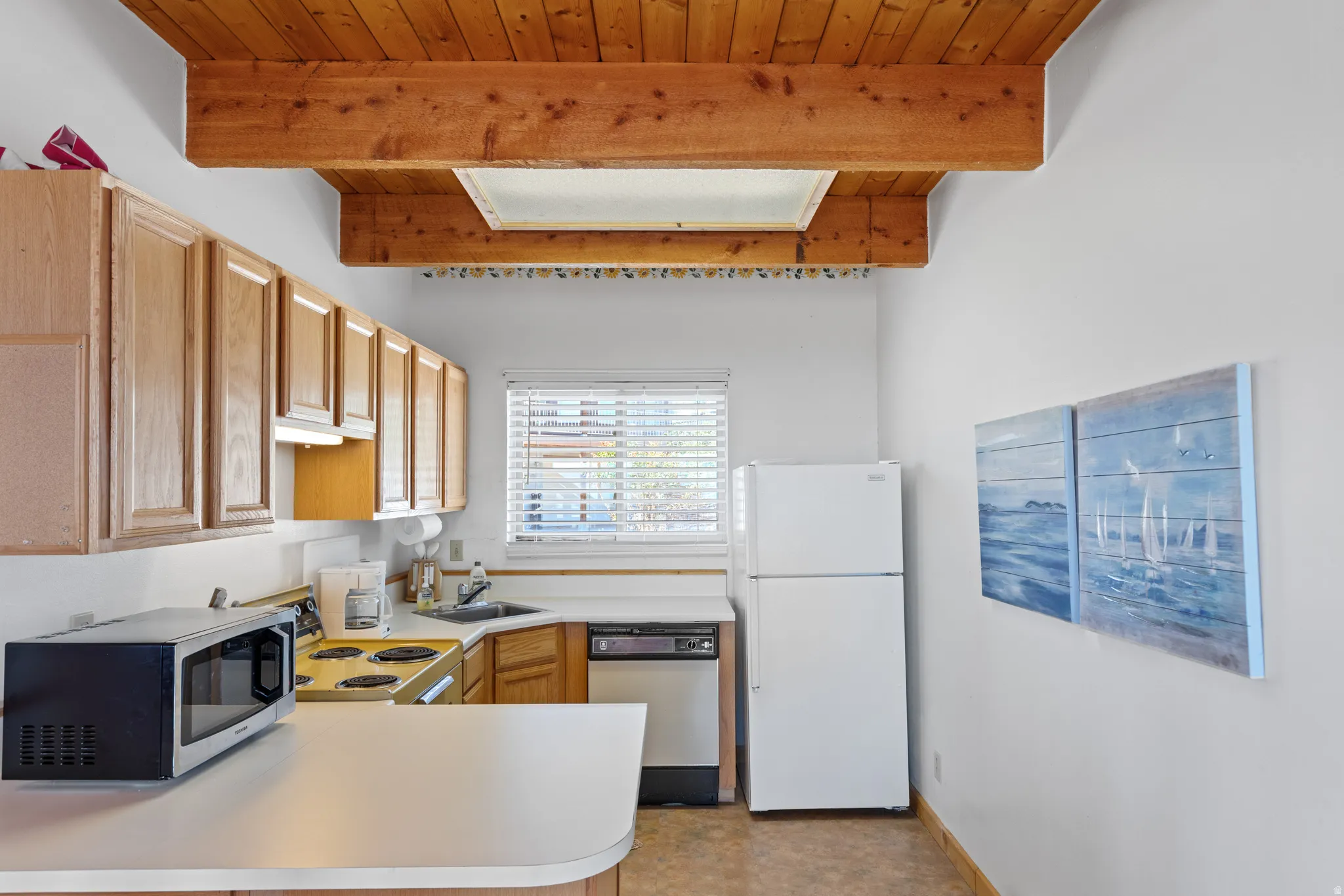 Wood-paneled vaulted ceiling with exposed beams and a skylight