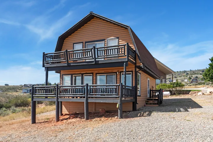 Two-story residential structure with gambrel roof and natural wood-finish siding
