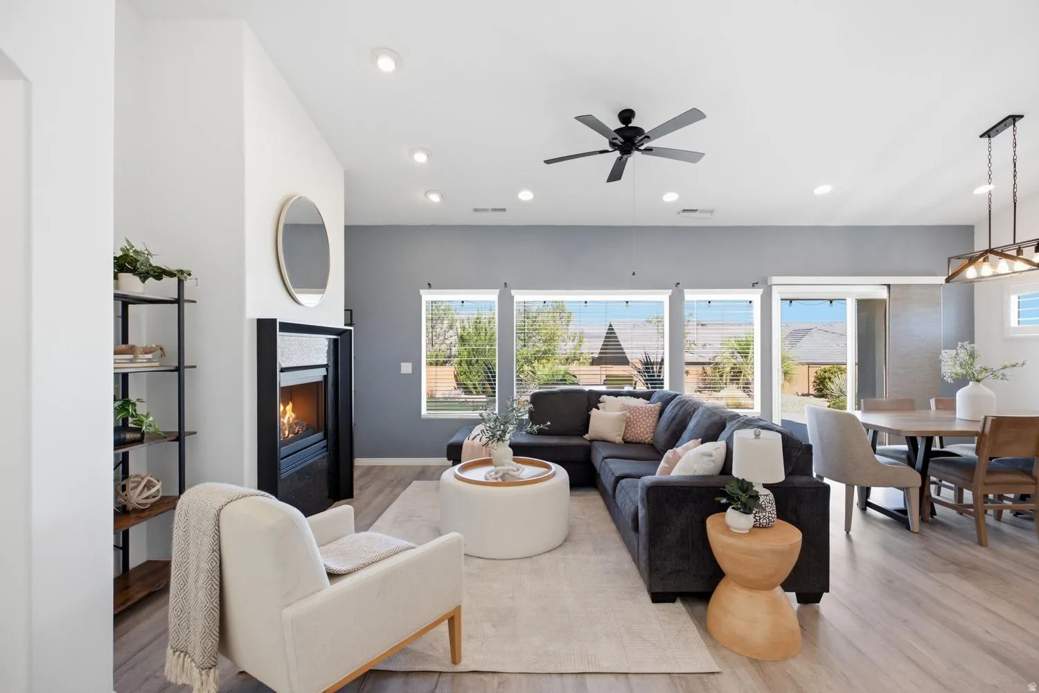 Open-concept living area with wood-finish flooring, a built-in fireplace, and recessed lighting