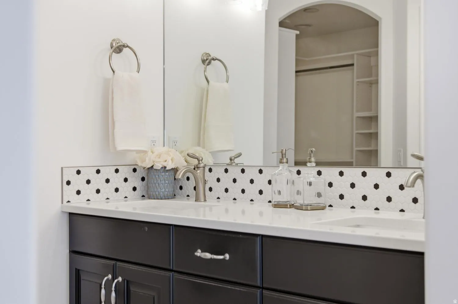 Dual vanity with under-mount sinks, a light-colored countertop, and a dark wood-finish cabinet