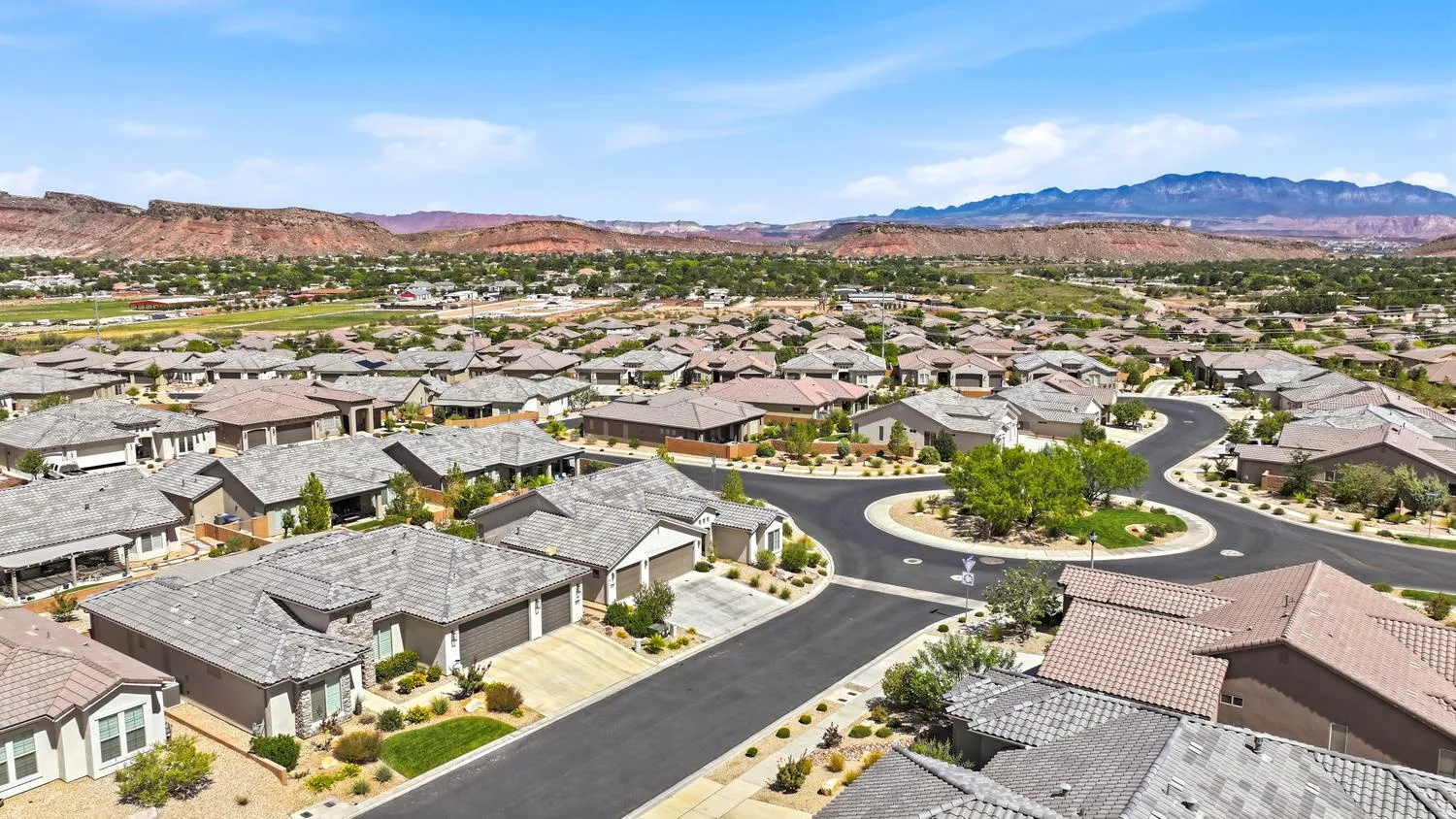 Residential neighborhood with mountain backdrop featuring a manicured roundabout