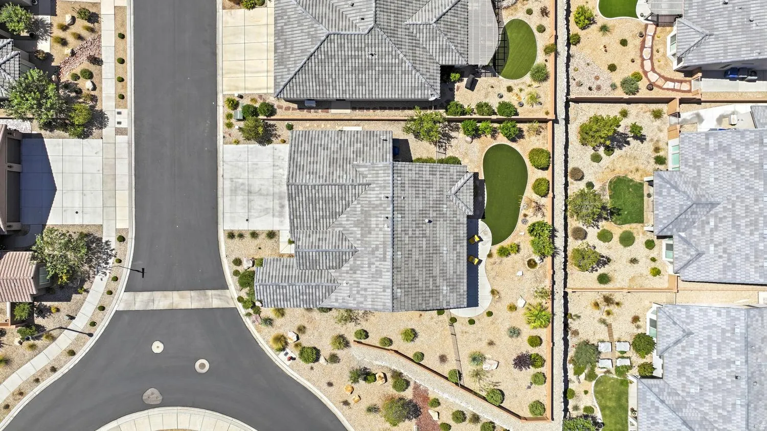 Residential neighborhood featuring paved streets, concrete sidewalks, and desert-style landscaping