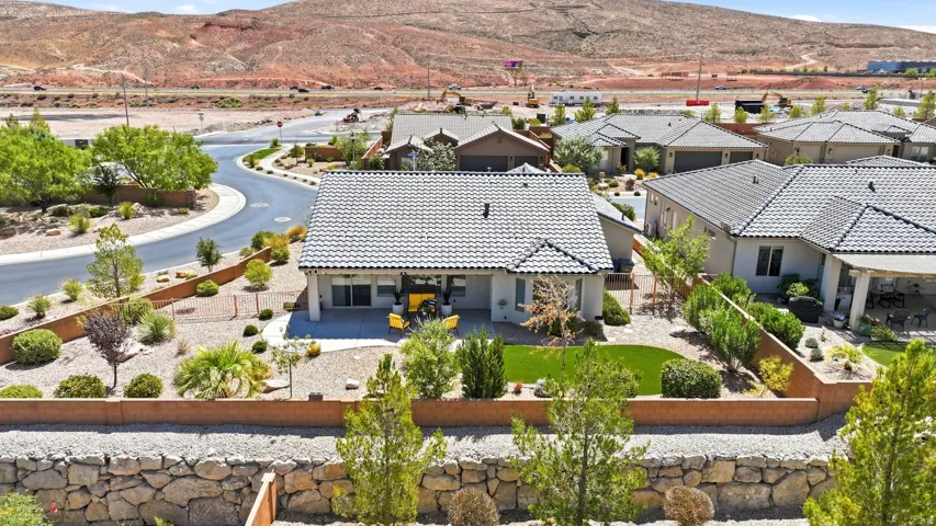 Backyard featuring a covered patio, turf lawn, and low-maintenance landscaping