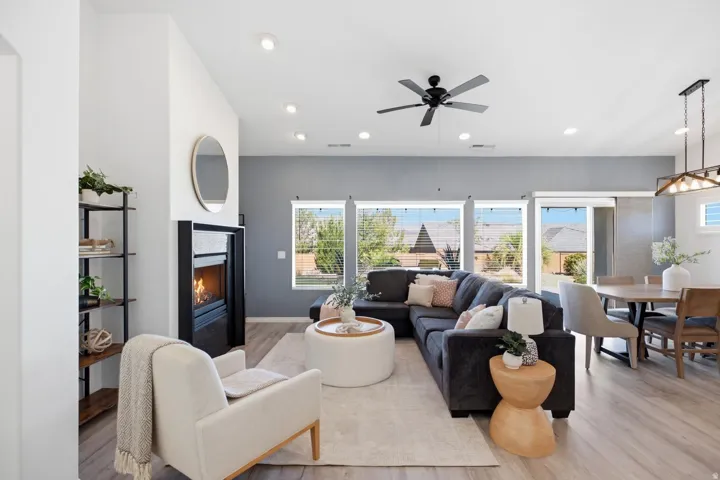 Open-concept living area with wood-finish flooring, a built-in fireplace, and recessed lighting