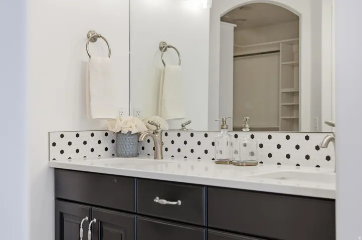 Dual vanity with under-mount sinks, a light-colored countertop, and a dark wood-finish cabinet