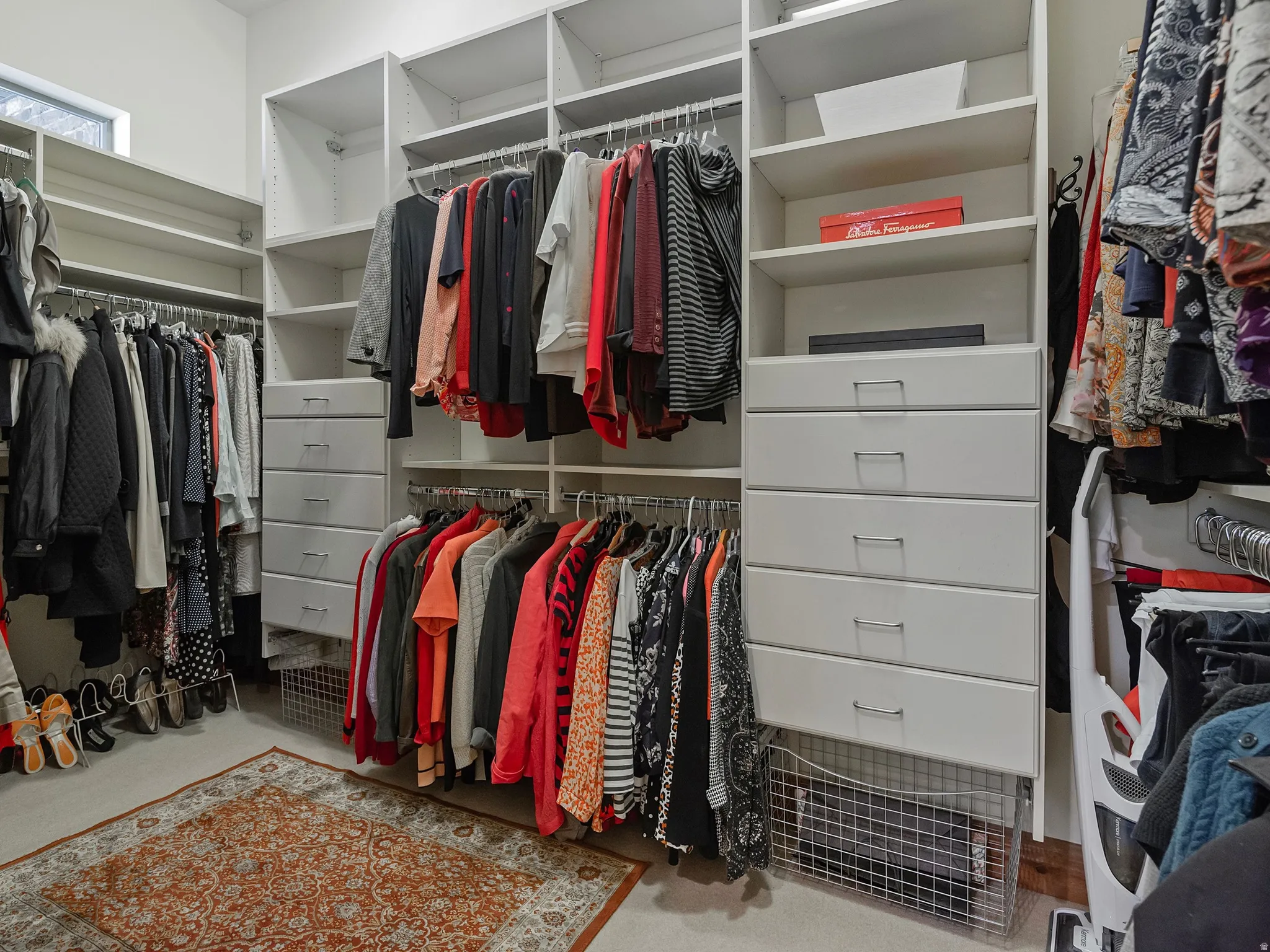 Custom closet system featuring multiple hanging rods, integrated shelving, and built-in drawers with modern pulls