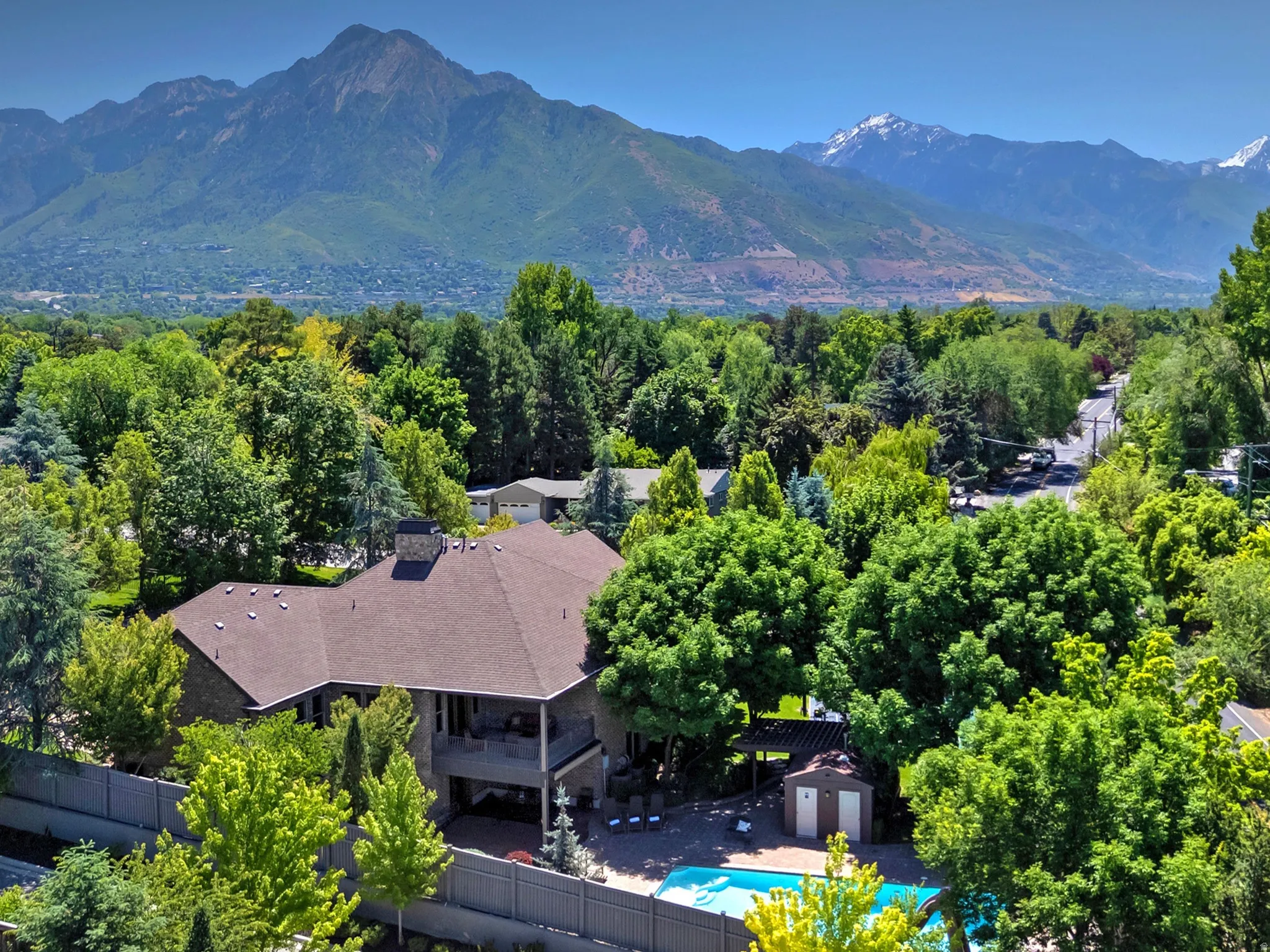 Expansive property featuring a multi-level structure with a gabled roof, a private swimming pool, and a dedicated pool shed