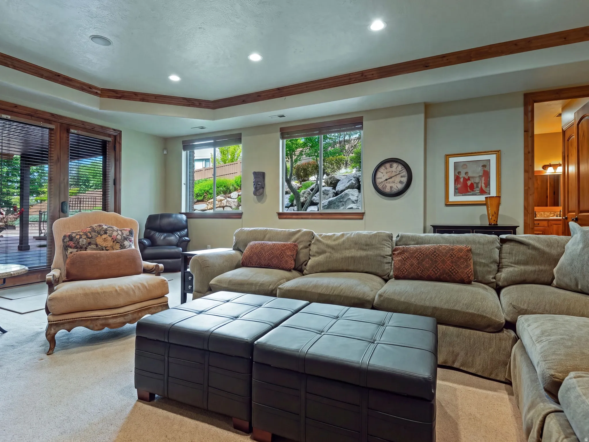 Recessed lighting illuminates the space, featuring a wood-trimmed ceiling and wood-finish door frames