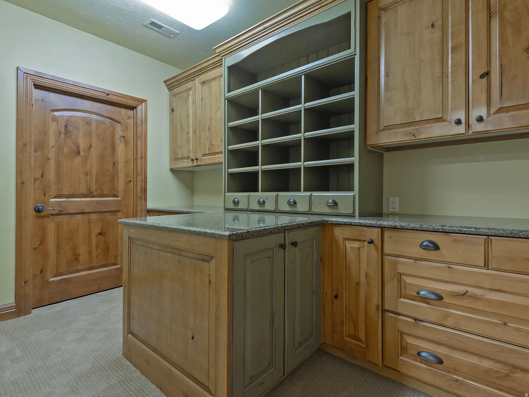 Craft & Storage Rooms, Wood-finish cabinetry with stone countertops, integrated open shelving, and a built-in desk area