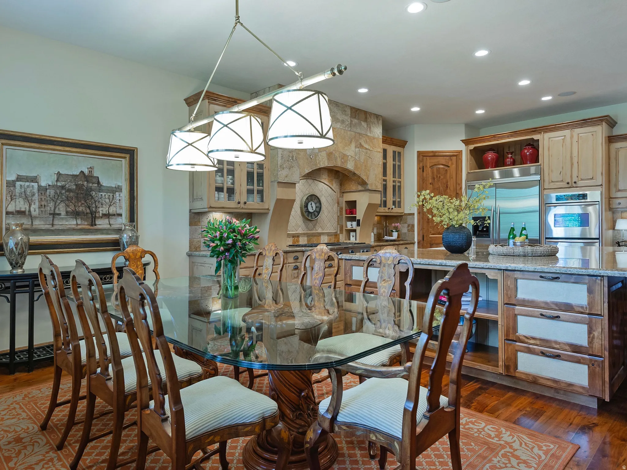Wood-finish flooring, recessed lighting, stone accent wall, custom wood cabinetry, and stainless steel appliances