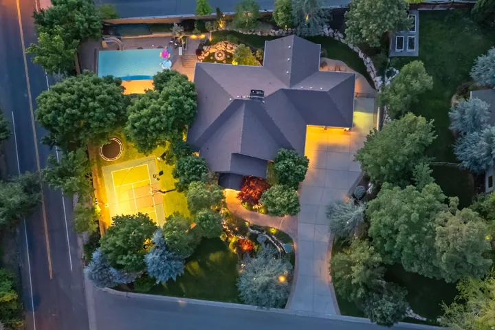 Expansive property featuring a swimming pool, tennis court, mature landscaping, paved driveway, and established walkway