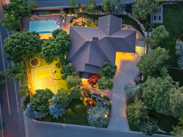 Expansive property featuring a swimming pool, tennis court, fire pit, and mature landscaping