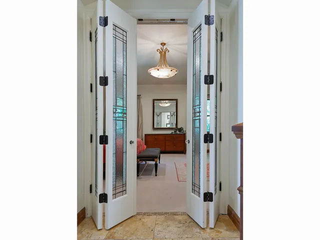 Primary Bedroom French doors with decorative glass panels and dark hardware