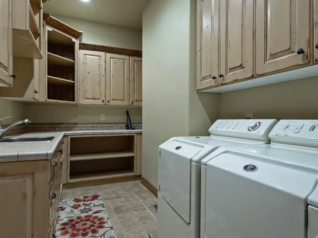 Built-in cabinetry with exposed shelving, tile flooring, ceramic tile countertop with integrated sink, and a tiled backsplash
