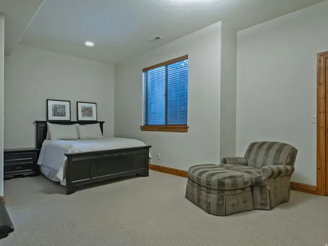 Carpeted room with a wooden door, wood window trim, and recessed lighting