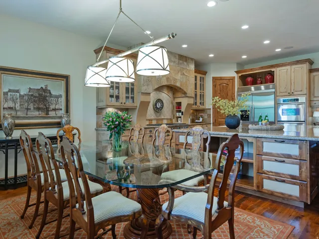 Wood-finish flooring, recessed lighting, stone accent wall, custom wood cabinetry, and stainless steel appliances
