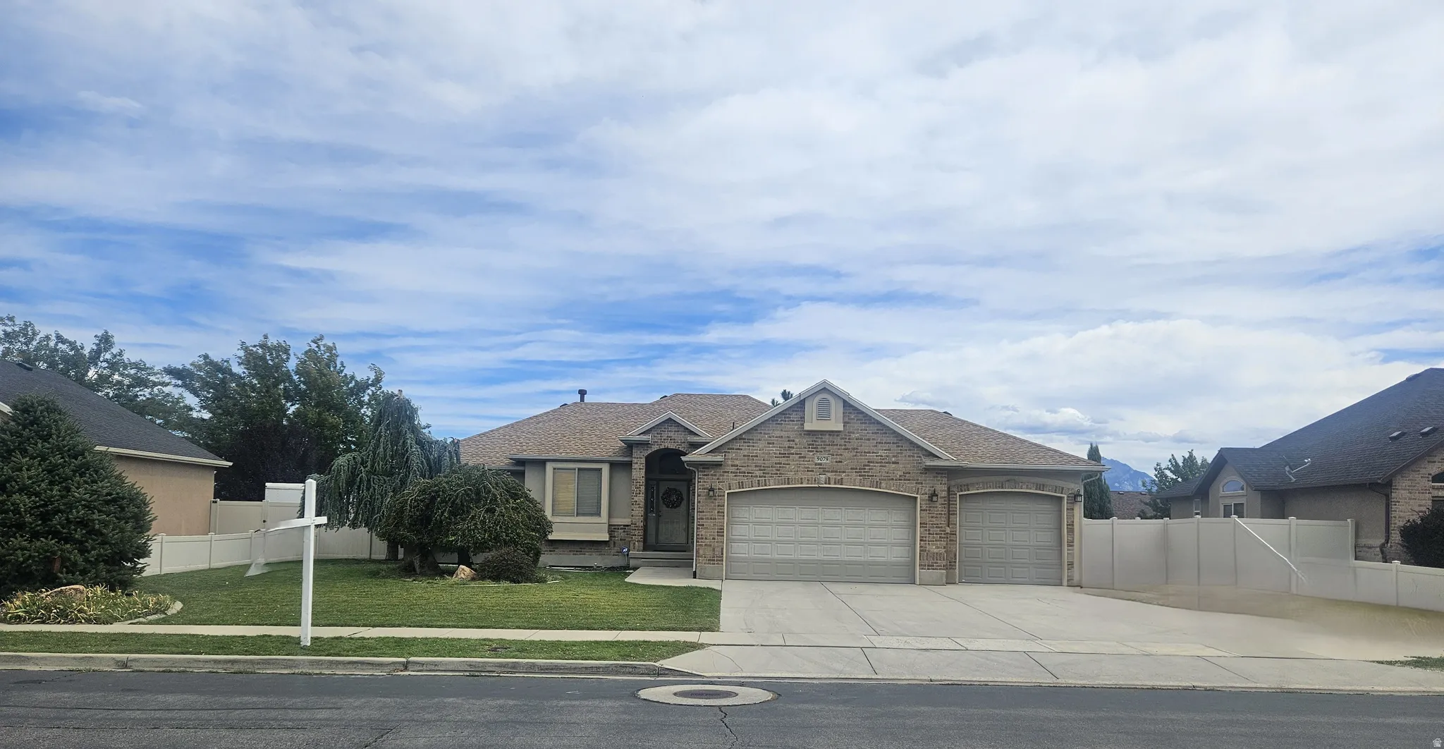 Brick/Stucco Exterior with Arched Entry Attached 3-car Oversized Garage, RV Parking, and Mature Landscaping