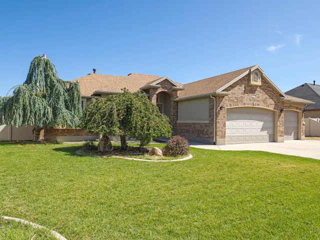 Brick exterior with a peaked roofline, attached two-car garage, and a concrete driveway