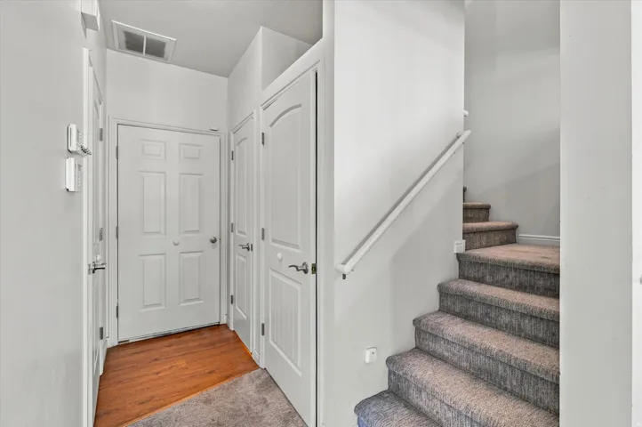 Carpeted staircase with wall-mounted handrail