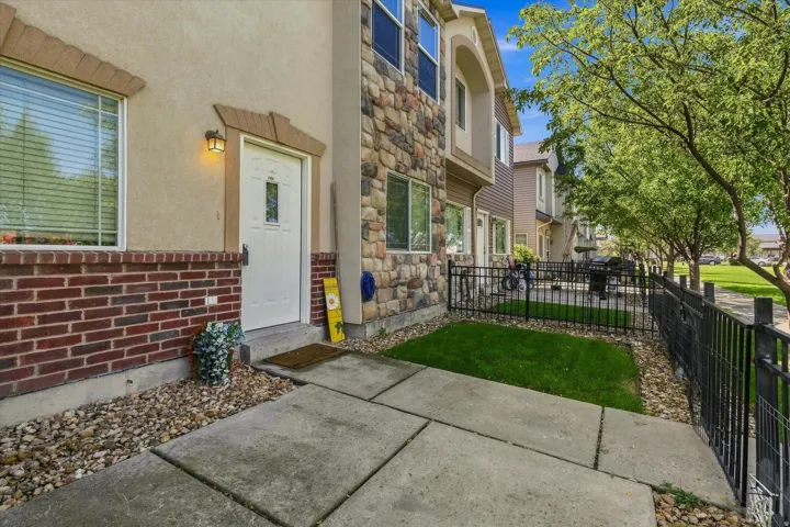 Exterior facade featuring brick and stone accents, a white entry door with frosted glass, and an exterior wall lantern