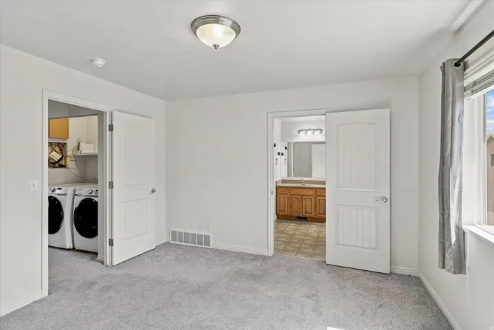 Wall-to-wall carpeting, overhead flush mount lighting, and a window with curtain rod
