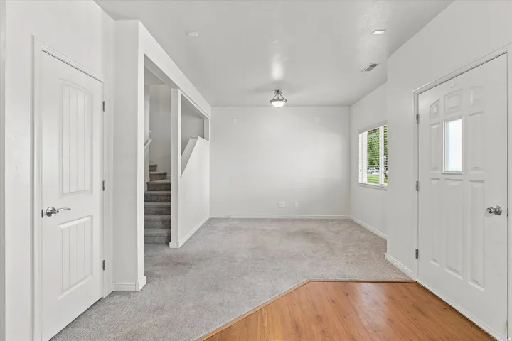Entryway featuring wood-finish flooring, a white paneled door with decorative glass, and recessed lighting