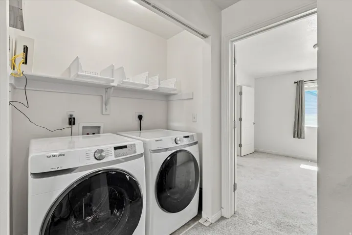 Laundry area featuring a built-in shelf with storage, utility hookups, and permanent overhead lighting