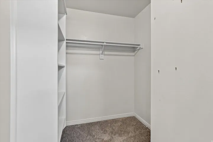 Built-in shelving, white walls, and a clothing rod