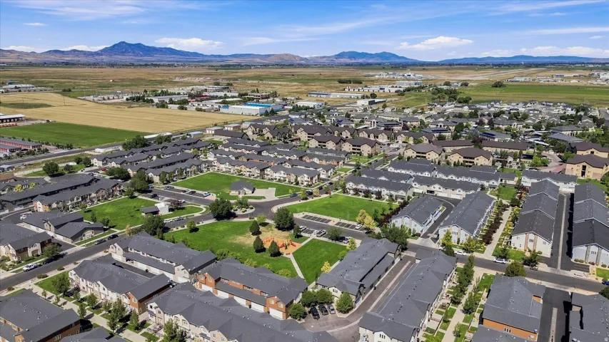 Expansive residential development featuring multiple buildings, manicured green spaces, and a playground structure